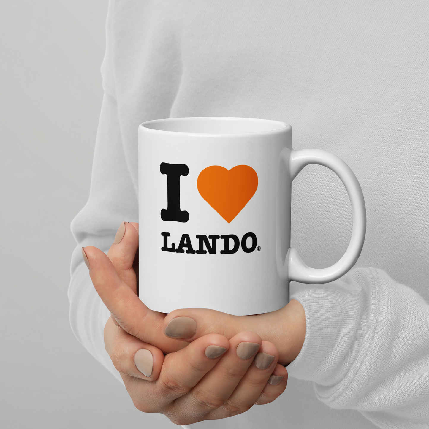White mug with 'I ❤️ LANDO' text held by a person against a gray background. Ideal for Lando Norris fans.